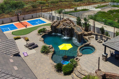 This is an example of a large coastal full sun backyard concrete paver and vinyl fence landscaping in Los Angeles for summer.