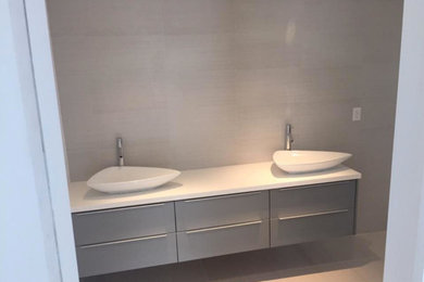 Bathroom - mid-sized transitional porcelain tile bathroom idea in Miami with flat-panel cabinets, gray cabinets, white walls and a vessel sink