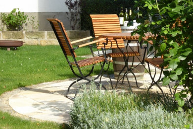 Esempio di un giardino country esposto in pieno sole di medie dimensioni in estate con un muro di contenimento e pavimentazioni in pietra naturale