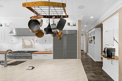 Inspiration for a huge contemporary galley porcelain tile, brown floor and shiplap ceiling eat-in kitchen remodel in Seattle with an undermount sink, shaker cabinets, white cabinets, quartz countertops, white backsplash, subway tile backsplash, stainless steel appliances, an island and beige countertops