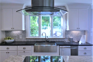 Example of a mid-sized minimalist l-shaped medium tone wood floor and brown floor open concept kitchen design in Atlanta with a farmhouse sink, shaker cabinets, white cabinets, marble countertops, multicolored backsplash, ceramic backsplash, stainless steel appliances and an island