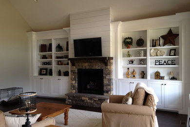 Mid-sized elegant enclosed dark wood floor and brown floor family room photo in Other with beige walls, a standard fireplace, a stone fireplace and a wall-mounted tv