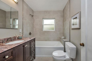 Mid-sized transitional 3/4 beige tile and ceramic tile beige floor bathroom photo in San Francisco with recessed-panel cabinets, dark wood cabinets, a two-piece toilet, beige walls, an undermount sink and granite countertops