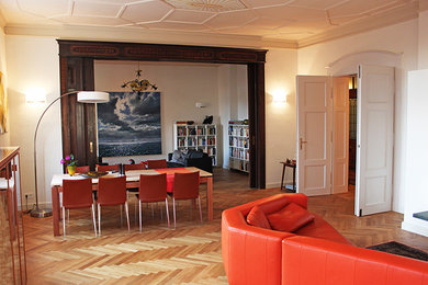 This is an example of a contemporary dining room in Nuremberg with white walls and medium hardwood floors.