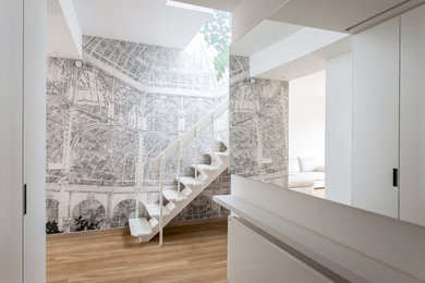 Inspiration for a mid-sized contemporary foyer in Milan with white walls, vinyl floors and beige floor.