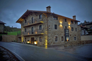 Inspiration for a mid-sized country three-storey exterior in Bilbao with stone veneer and a gable roof.