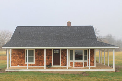 Example of a small cottage one-story wood exterior home design in Other