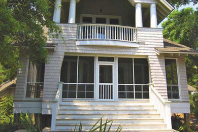 Large beach style gray two-story wood exterior home photo in New York with a shingle roof