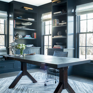 Expansive transitional home office in New York with a library, blue walls, dark hardwood floors, no fireplace and a freestanding desk.