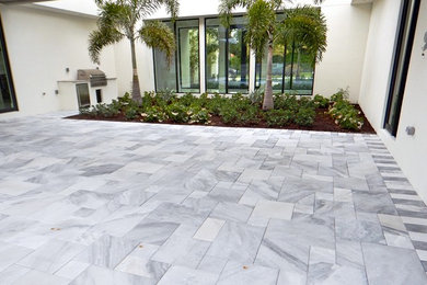 Patio kitchen - large modern backyard stone patio kitchen idea in Tampa with no cover