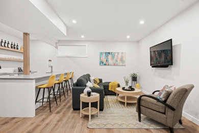 Small trendy open concept vinyl floor and brown floor living room photo in Calgary with a bar, gray walls and a wall-mounted tv