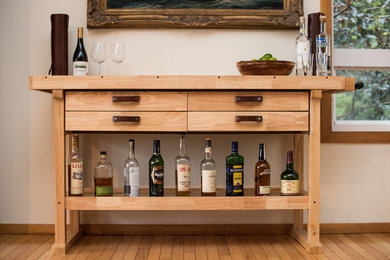 Photo of a mid-sized industrial single-wall bar cart in Portland with light wood cabinets, wood benchtops, white splashback and beige benchtop.