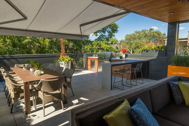 This is an example of a contemporary rooftop and rooftop deck in Chicago with an awning.