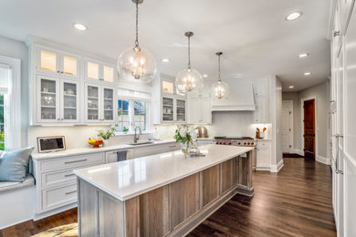 Large elegant dark wood floor and brown floor kitchen photo in Columbus with beaded inset cabinets, white cabinets, quartz countertops, white backsplash, quartz backsplash, paneled appliances, an island and white countertops