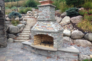 Photo of a large traditional backyard garden in Minneapolis with a fire feature and concrete pavers.
