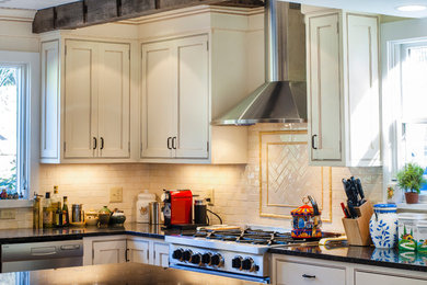 Inspiration for a transitional u-shaped medium tone wood floor kitchen remodel in New York with a farmhouse sink, beaded inset cabinets, white cabinets, granite countertops, beige backsplash, subway tile backsplash, stainless steel appliances and an island