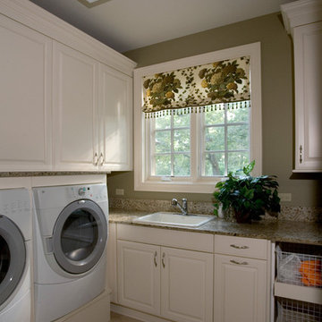 Laundry room with raised-panel overlay doors in white and built-in front loading