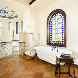 Idées déco pour une salle de bain méditerranéenne avec une baignoire sur pieds, des carreaux en terre cuite, un sol en carreau de terre cuite et une douche à l'italienne.