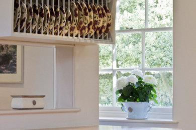 This is an example of a large classic kitchen/diner in Other with a double-bowl sink, recessed-panel cabinets, grey cabinets, wood worktops, stone slab splashback, black appliances, limestone flooring and a breakfast bar.