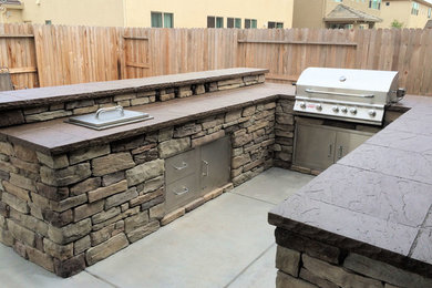 Large arts and crafts backyard patio in Other with an outdoor kitchen, concrete slab and a pergola.