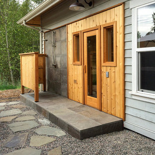 This is an example of a mid-sized contemporary backyard patio in Seattle with an outdoor shower, gravel and a roof extension.