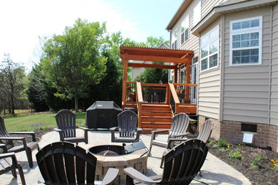 Inspiration for a mid-sized craftsman backyard deck remodel in Charlotte with a fire pit and a pergola