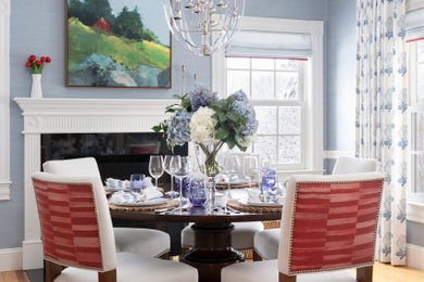 Inspiration for a mid-sized transitional separate dining room in Boston with blue walls, a standard fireplace and wallpaper.