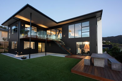 Imagen de fachada de casa negra contemporánea grande de dos plantas con revestimiento de madera y tejado de metal