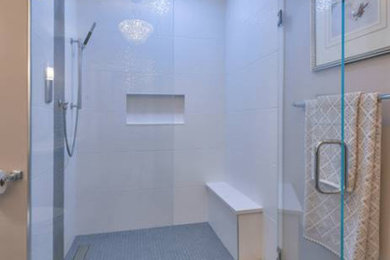 На фото: маленькая ванная комната в стиле модернизм с фасадами с утопленной филенкой, светлыми деревянными фасадами, угловым душем, раздельным унитазом, желтой плиткой, керамической плиткой, бежевыми стенами, полом из плитки под дерево, душевой кабиной, врезной раковиной, столешницей из гранита, коричневым полом, душем с распашными дверями, белой столешницей, сиденьем для душа, тумбой под две раковины и напольной тумбой для на участке и в саду с