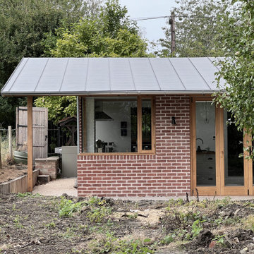 Kitchen extension with brick walls, oak joinery and a zinc roof