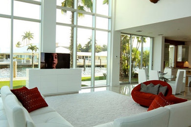 Photo of a large modern formal open concept living room in Miami with no fireplace, white walls, a concealed tv and marble floors.