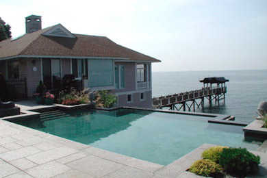 Large elegant backyard stone and custom-shaped lap pool house photo in New York