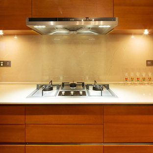 Immagine di una cucina contemporanea di medie dimensioni con ante lisce, ante in legno scuro, top in pietra calcarea, paraspruzzi beige, paraspruzzi in lastra di pietra e elettrodomestici in acciaio inossidabile