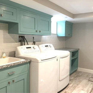 Ejemplo de cuarto de lavado lineal, contemporáneo, de tamaño medio, con fregadero sobremueble, armarios estilo shaker, puertas de armario turquesas, encimera de granito, paredes grises, suelo de madera en tonos medios, suelo multicolor y encimeras multicolor