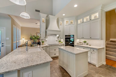 Kitchen - mid-sized transitional u-shaped kitchen idea in Dallas with an undermount sink, shaker cabinets, white cabinets, granite countertops, white backsplash, paneled appliances and an island