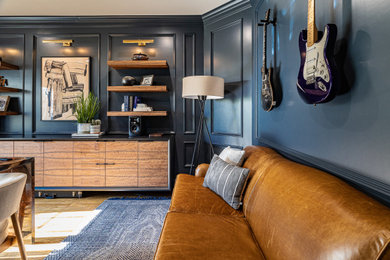Ejemplo de despacho tradicional grande con paredes azules, suelo de madera en tonos medios, escritorio empotrado, suelo marrón y panelado