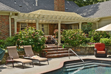 Example of a large classic backyard brick pool fountain design in Other