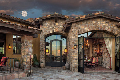Large country backyard patio in Phoenix with natural stone pavers and a roof extension.