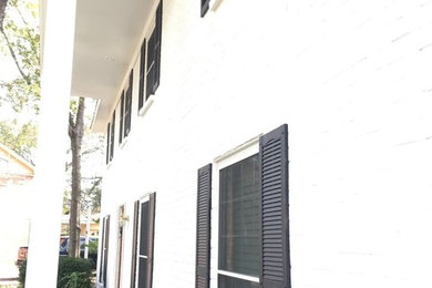 Foto de fachada blanca clásica de tamaño medio de dos plantas con revestimiento de ladrillo