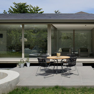 他の地域のモダンスタイルのおしゃれな前庭のテラス (タイル敷き、張り出し屋根) の写真