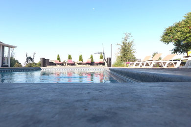 Example of a mid-sized transitional backyard brick and rectangular lap pool house design in Other
