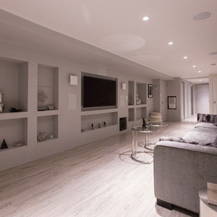 Design ideas for a large modern open plan home cinema in New York with grey walls, bamboo flooring and a wall mounted tv.