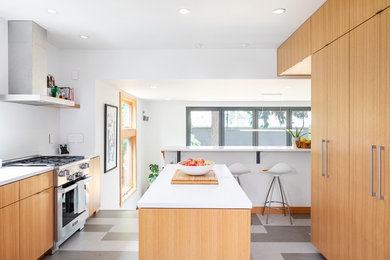 Small contemporary galley kitchen in Seattle with an undermount sink, flat-panel cabinets, light wood cabinets, quartz benchtops, white splashback, ceramic splashback, stainless steel appliances, linoleum floors, with island, multi-coloured floor and white benchtop.