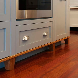 Design ideas for a large modern u-shaped kitchen pantry in Burlington with a farmhouse sink, flat-panel cabinets, white cabinets, wood benchtops, multi-coloured splashback, panelled appliances, dark hardwood floors and with island.