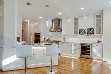 Example of a small trendy u-shaped kitchen design in DC Metro with an undermount sink, recessed-panel cabinets, white cabinets, quartzite countertops, stainless steel appliances and a peninsula