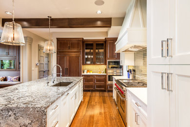 Open concept kitchen - large transitional l-shaped medium tone wood floor and brown floor open concept kitchen idea in Chicago with shaker cabinets, an island, stainless steel appliances, a drop-in sink, dark wood cabinets, granite countertops, beige backsplash and glass tile backsplash