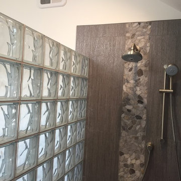 Decorative pebble tile shower insert and an obscure glass block privacy wall