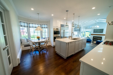 Example of a mid-sized galley dark wood floor, brown floor and coffered ceiling eat-in kitchen design in Chicago with a drop-in sink, beaded inset cabinets, gray cabinets, quartzite countertops, white backsplash, mosaic tile backsplash, stainless steel appliances, an island and white countertops