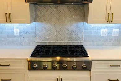 Mid-sized transitional u-shaped dark wood floor and brown floor eat-in kitchen photo in DC Metro with a farmhouse sink, recessed-panel cabinets, white cabinets, quartz countertops, white backsplash, marble backsplash, stainless steel appliances, an island and white countertops