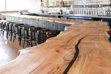 Ejemplo de bar en casa con barra de bar en L de estilo americano grande con encimera de madera y encimeras marrones